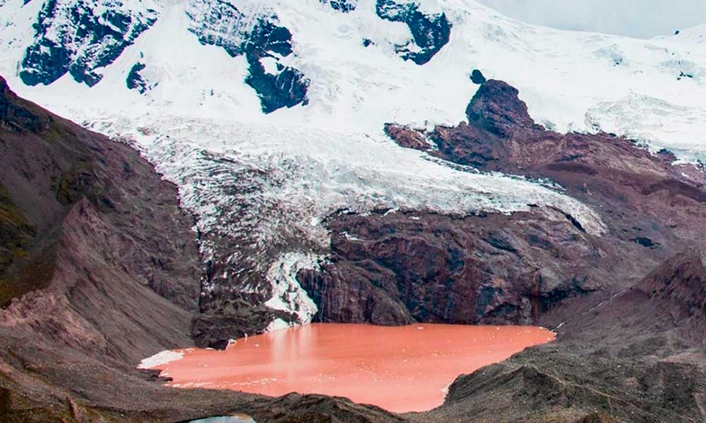 Hikers resting by the peaceful Qomercocha Lake, part of the 7 Lakes of Ausangate