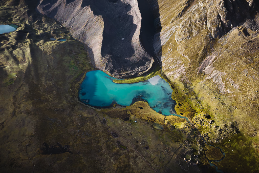 The crystal-clear waters of Azulcocha Lake, nestled in the Andes with views of Ausangate Mountain Peru